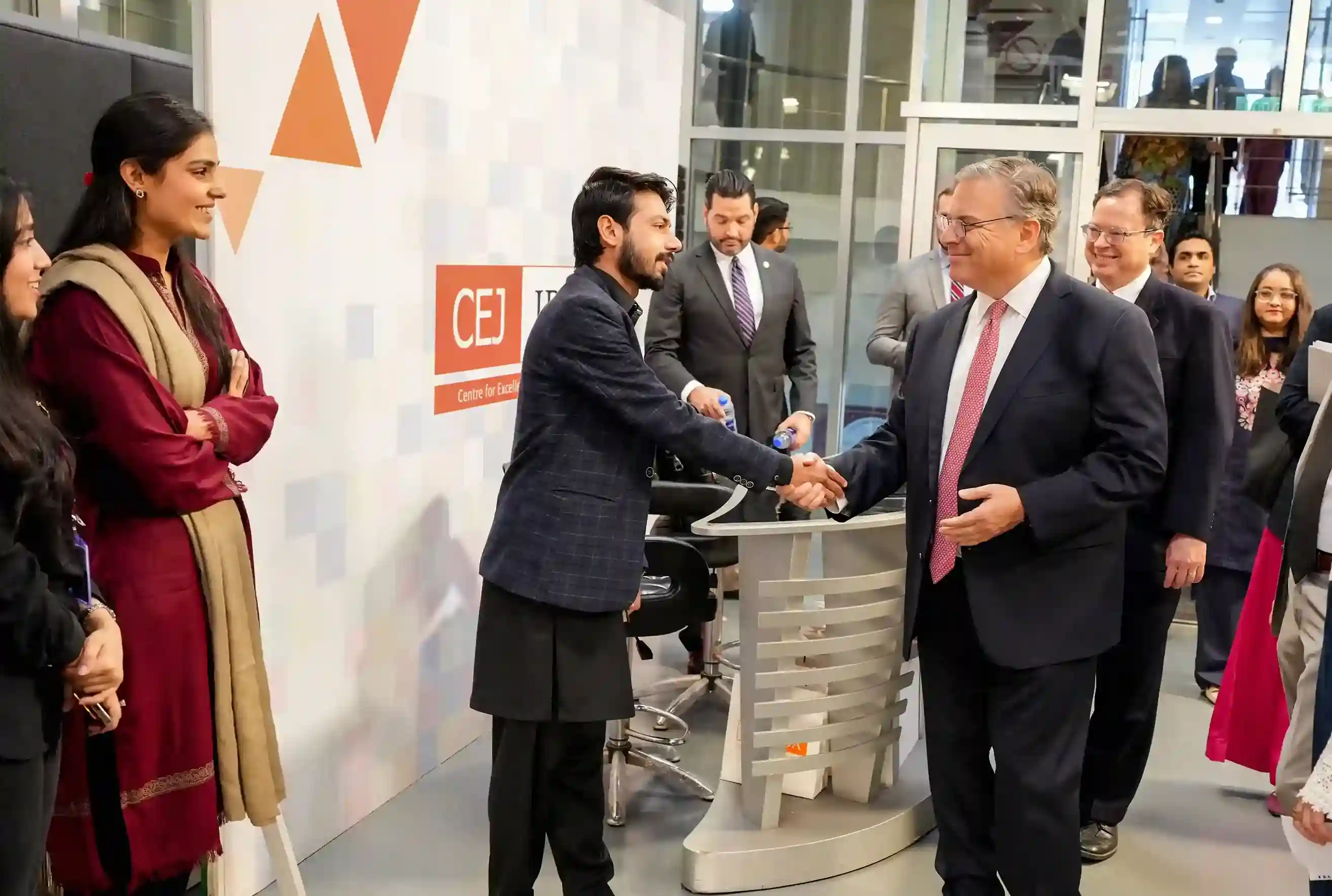 US Ambassador Donald Blome and the US Consulate General Karachi delegation standing with faculty and leadership inside the state-of-the-art broadcast studio and multimedia newsroom at the Center for Excellence in Journalism (CEJ), IBA Karachi